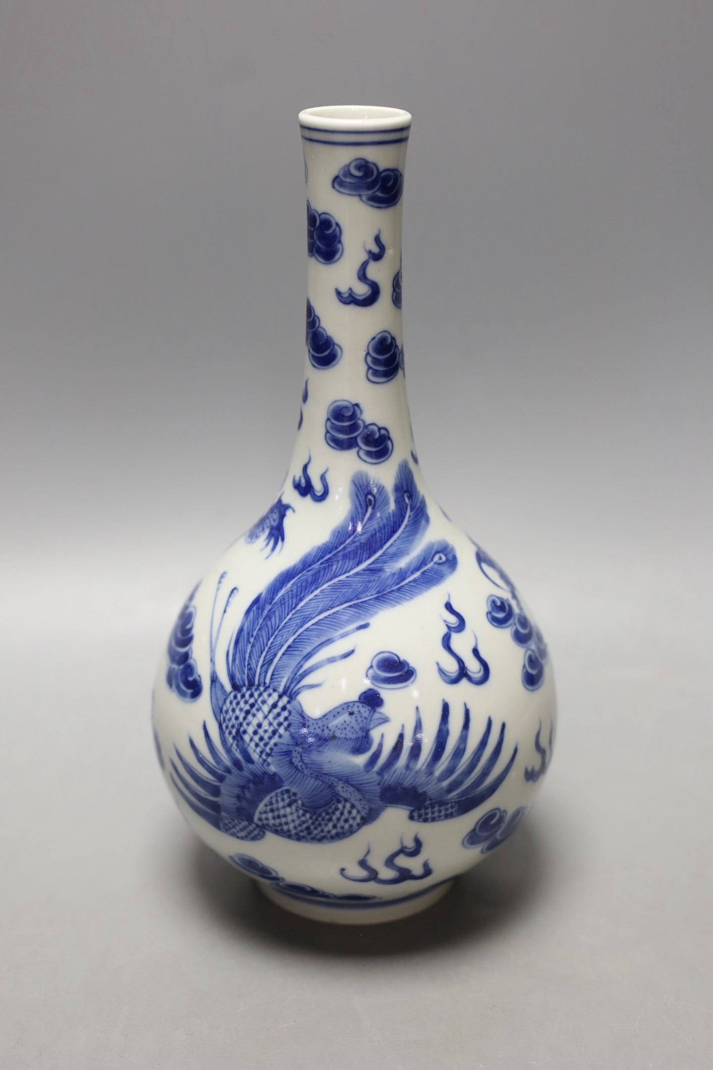 A Chinese blue and white ‘dragon and phoenix’ bottle vase, 23 cms high.